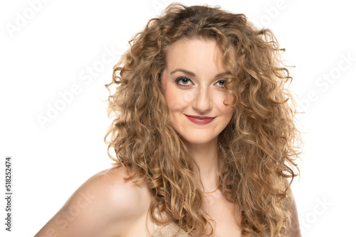 Attractive blonde woman with curly beautiful hair smiling on white background