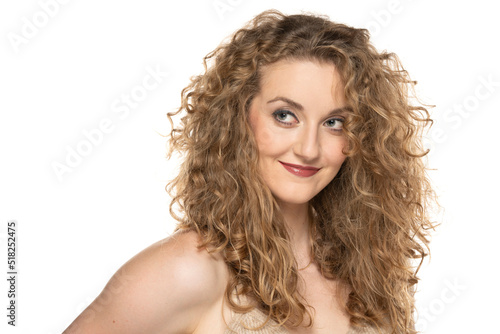 Attractive blonde woman with curly beautiful hair smiling on white background