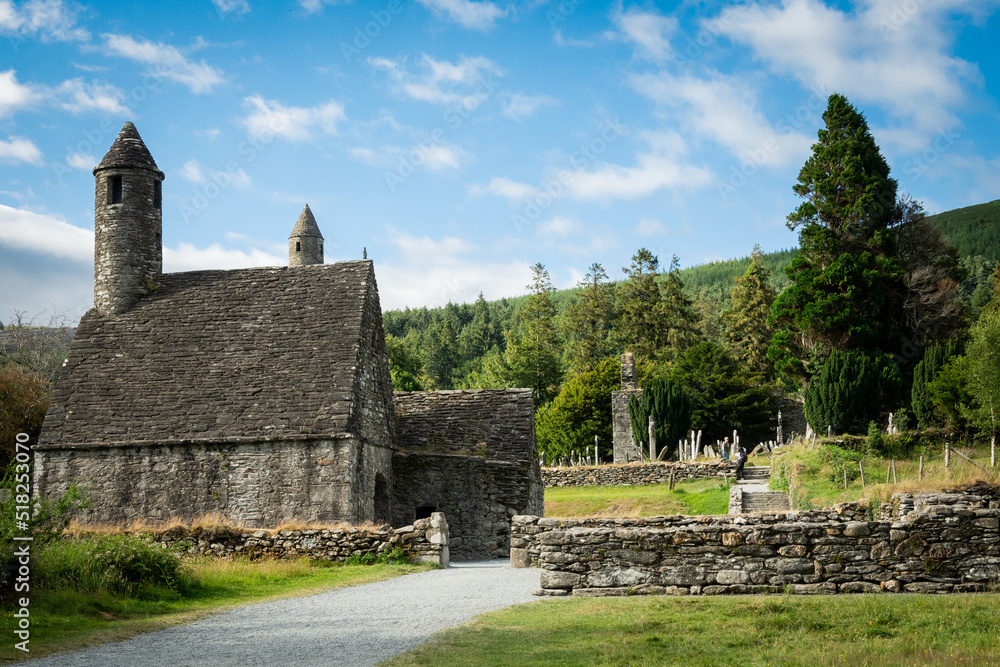 Saint Kevin's church in the Glendalough monastery in Co Wicklow Ireland set in a valley on a sunny day showing perfectly green natural countryside. Irish tourist attraction
