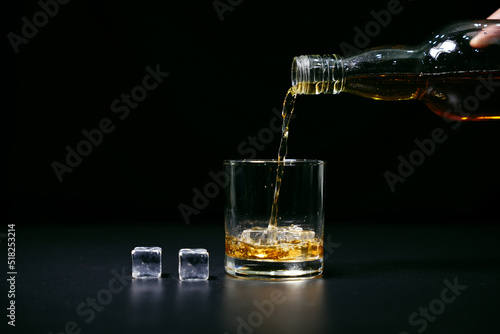 Closeup Barman pouring whiskey into glass