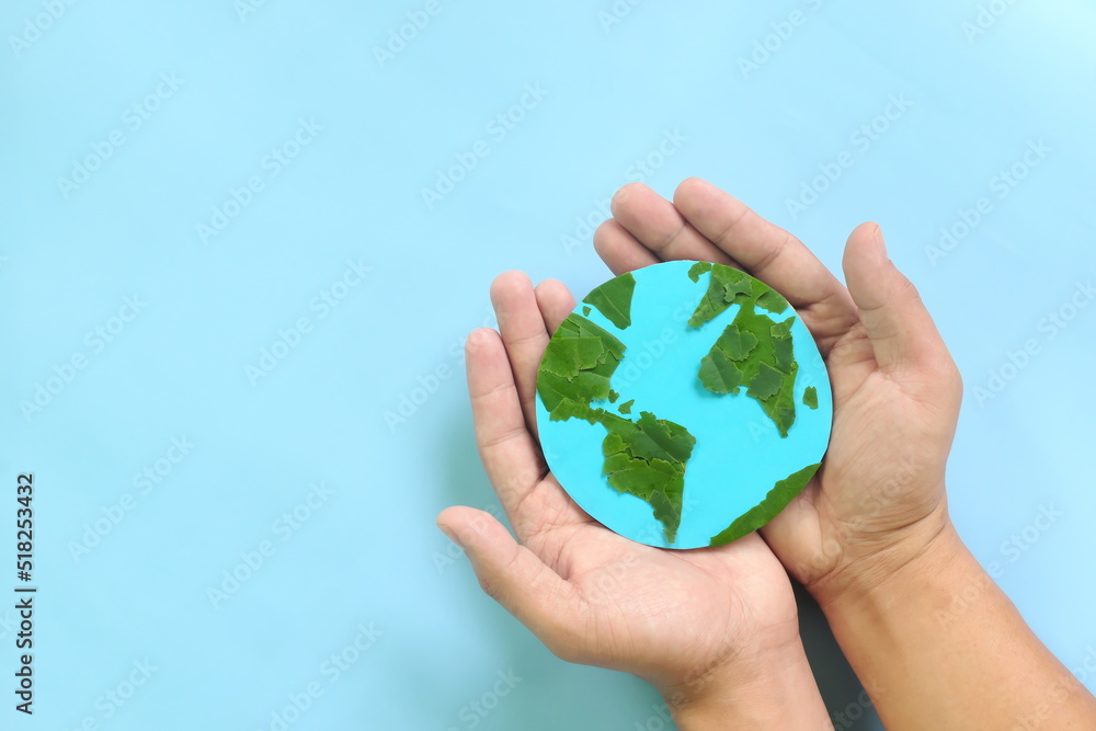 Top view of human hand holding planet earth model with green leaves. World earth day, save the environment, environmental conservation, protection, esg and csr concept. Top view of human hand holding planet earth model with green leaves. World earth day, save the environment, environmental conservation, protection, esg and csr concept.