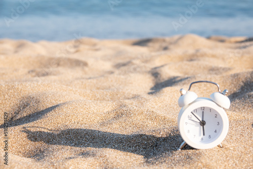 Last minute to count down for travel or travel vacation concept. metaphor by old retro clock on sand beach.