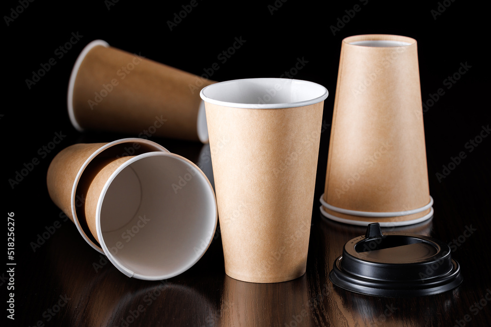 Disposable brown paper cup with black lid without logo on black ...