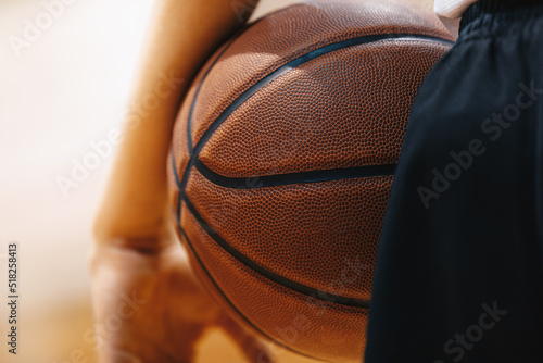 Basketball player holding game ball. Basketball training session. Closeup image of basketball © matimix