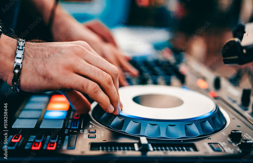 DJ Hands creating and regulating music on dj console mixer in concert outdoor