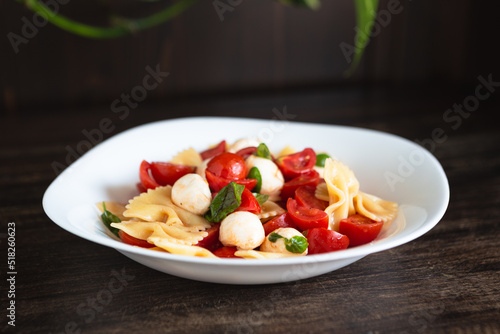 Pasta salad with tomato, mozzarella and basil. Quick and cold summer dish, ideal for a vegetarian diet. Convenient food to take to the office.