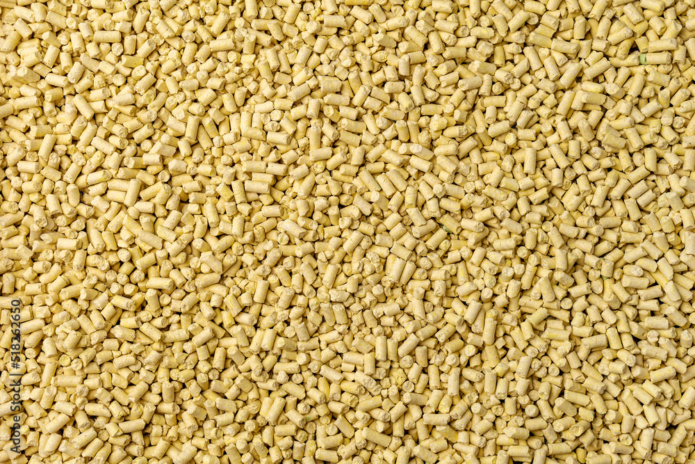 Hygienic natural clumping cat litter. Texture of vegetable fiber granules. Yellow corn tofu close up. Hygienic natural clumping cat litter. Texture of vegetable fiber granules. Yellow corn tofu close up.