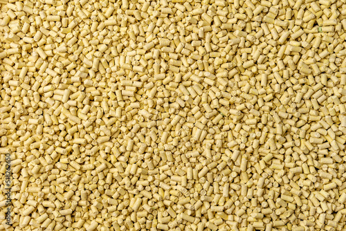 Hygienic natural clumping cat litter. Texture of vegetable fiber granules. Yellow corn tofu close up.