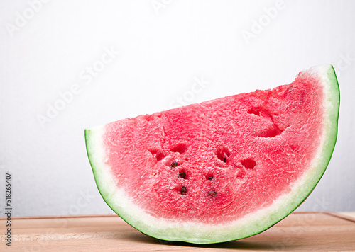 a piece of ripe red watermelon on a wooden table