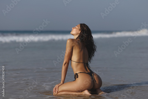 Summer is the perfect time to be sexy. Fashion shot of a gorgeous young woman in black bikini on the beach. High quality photo