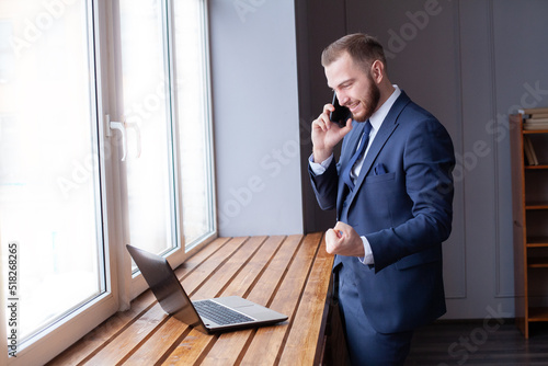 Businessman executive using smartphone and laptop indoor