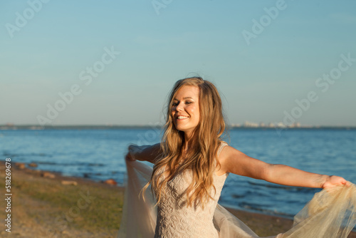 Happy woman feeling free with open arms and breating clean air on sea