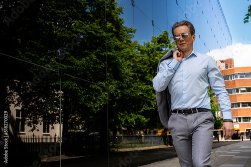 A handsome businessman in a grey suit in an urban city environment