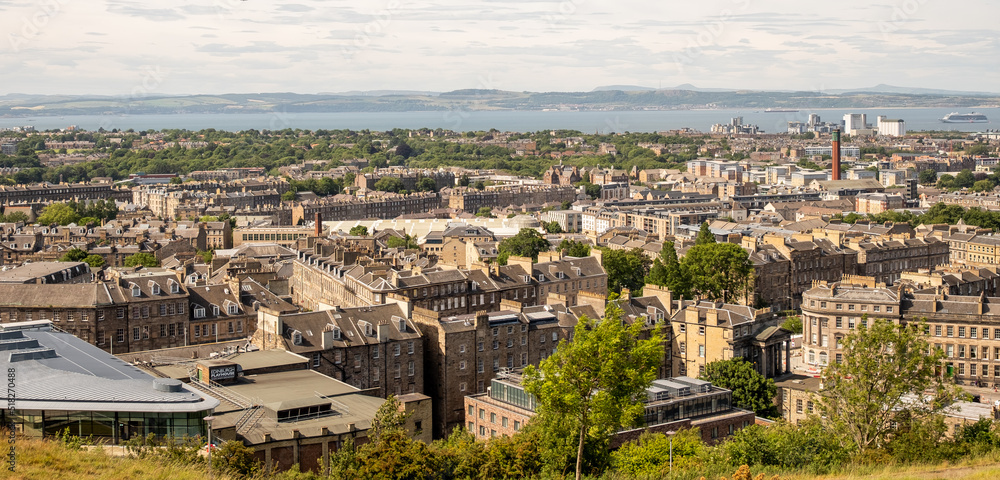 Edinburgh, Scotland, UK – June 20 2022. A view over the Edinburgh skyline towards the Firth of the Forth captured from Calton Hill
