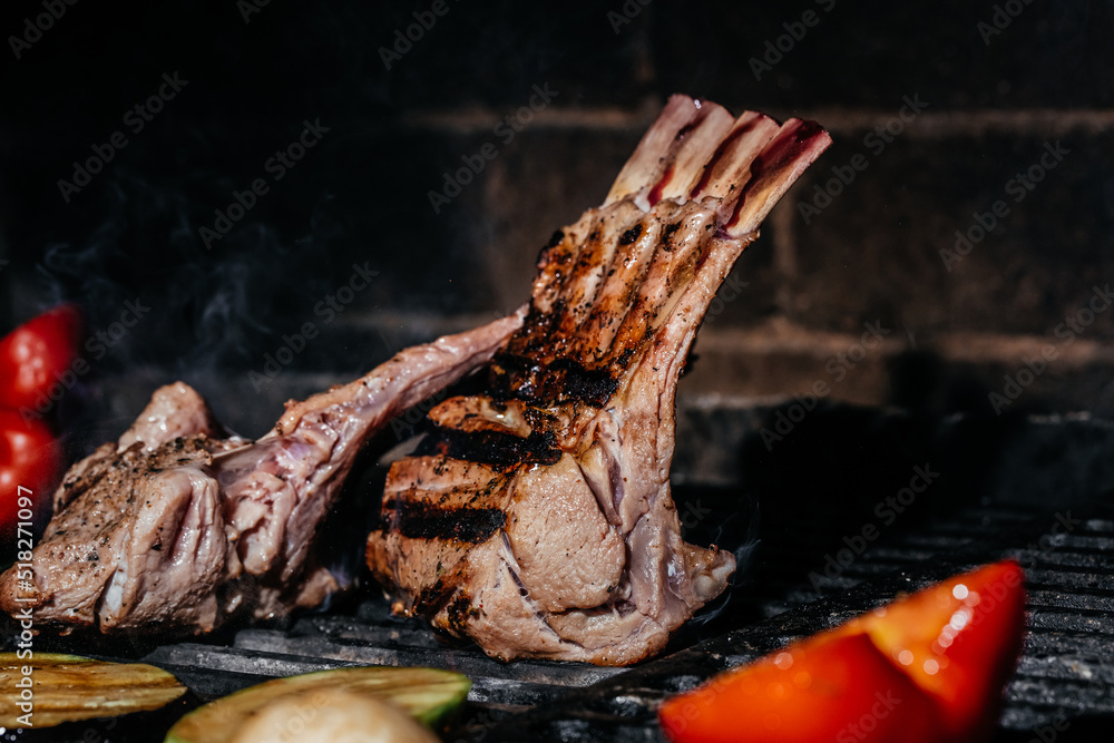 Meat lamb on the grill. Lamb ribs on board with grilled vegetables