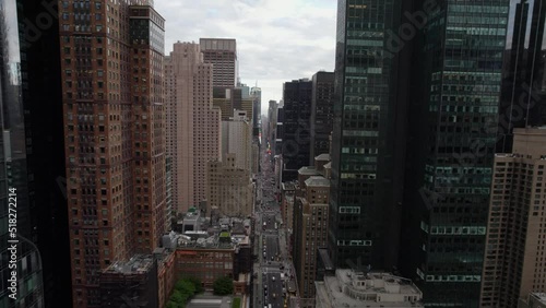 Flying between buildings towards the Times square in cloudy, New York, USA - Aerial view photo