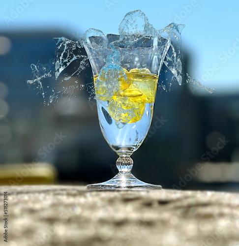 glass of water  and  drops splas with lemon  on beach at sunset nature landscape photo