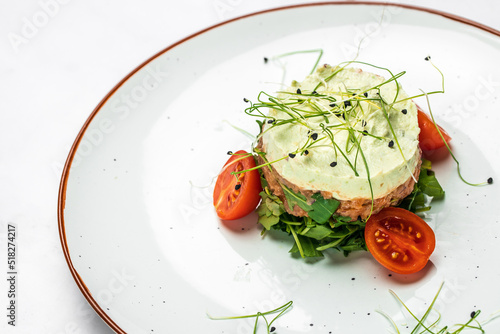 salmon tartar. Raw salmon, avocado purple onion salad, delicious avocado served with arugula, Restaurant menu, dieting, cookbook recipe top view photo