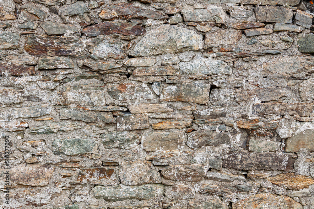 Natural ancient stone fence. Grunge stone wall granite background texture. Part of an old vintage castle stone barrier. Natural ancient stone fence. Grunge stone wall granite background texture. Part of an old vintage castle stone barrier.