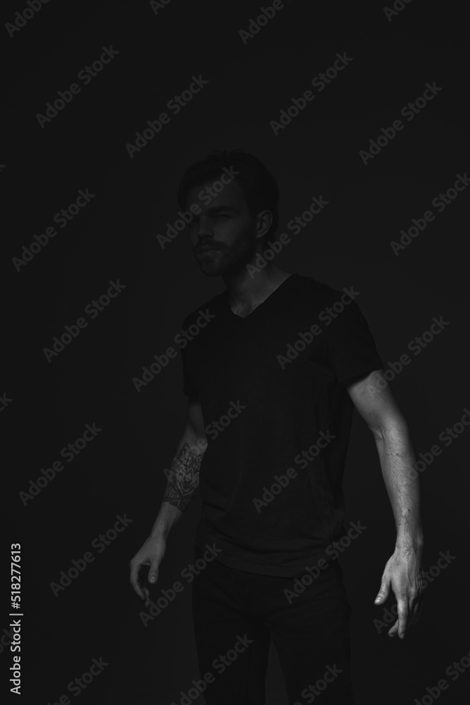 Naklejka premium Portrait of a man in a dark key in the studio