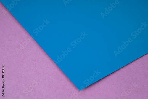Plain blue paper sheet lying on pink textured Background like an open book from top angle