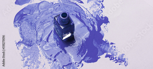 Cornflower blue nail polish bottle on backdrop smear background. Manicure and pedicure concept