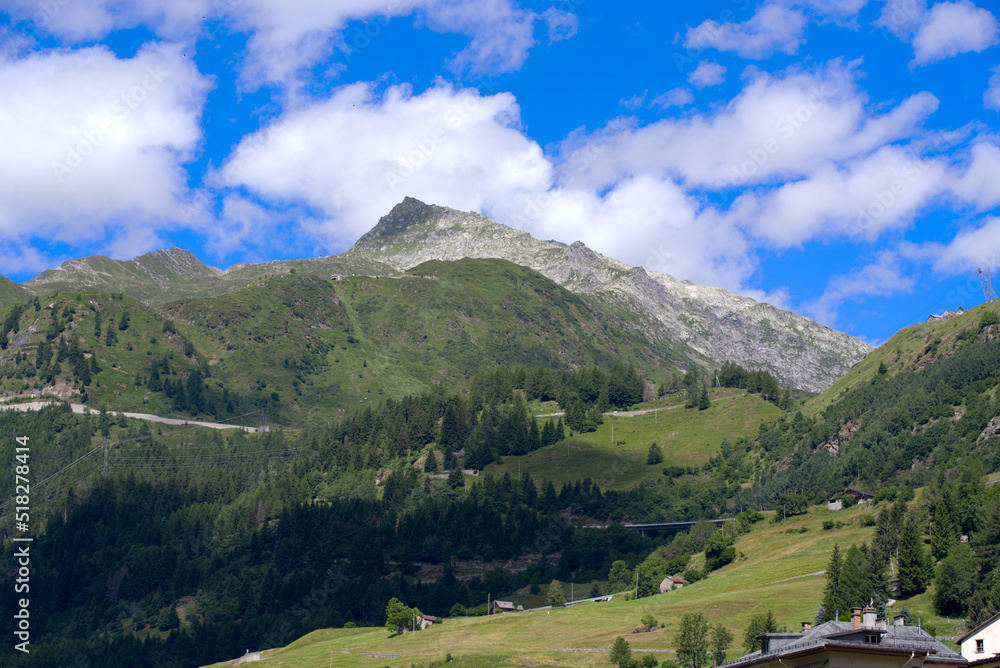 Mountain panorama seen from mountain village Airolo, Canton Uri, on a sunny summer day. Photo taken June 25th, 2022, Airolo, Switzerland.
