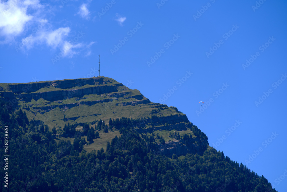 Top of mount Rigi with communications tower and paraglider on a sunny summer day. Photo taken June 25th, 2022, Airolo, Switzerland.