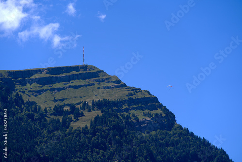 Fototapeta Naklejka Na Ścianę i Meble -  Top of mount Rigi with communications tower and paraglider on a sunny summer day. Photo taken June 25th, 2022, Airolo, Switzerland.