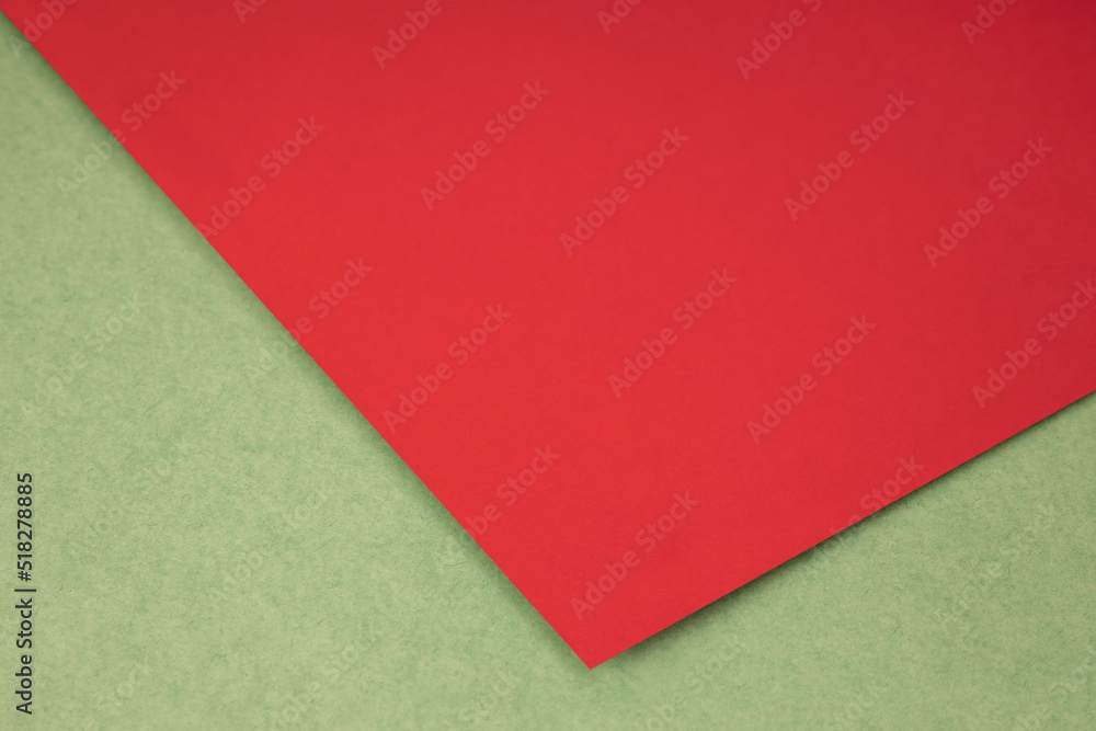 Plain red paper sheet lying on green brown textured Background like an open book from top angle Plain red paper sheet lying on green brown textured Background like an open book from top angle