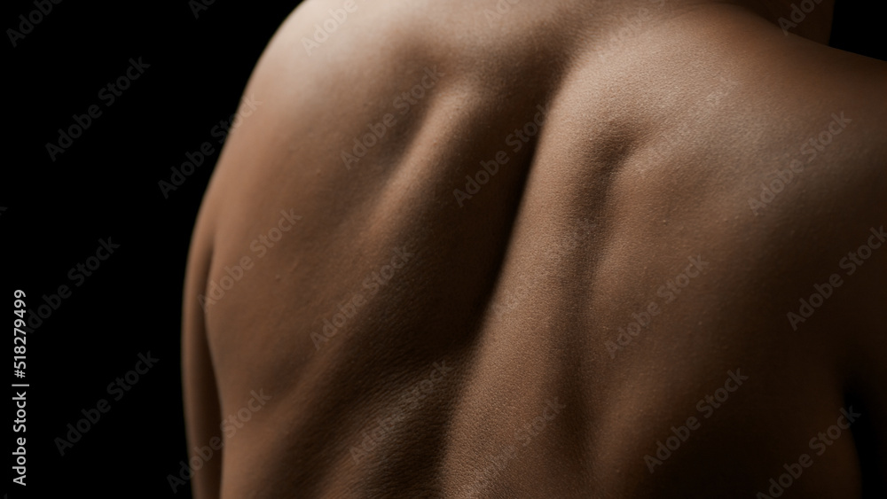 Naklejka premium Close-up shot of young good-looking slim African American female model's shoulders on black background | Skin nutrition concept