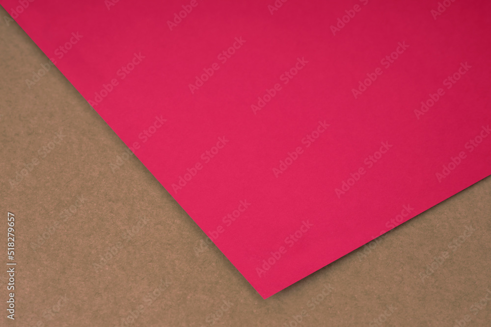 Plain neon pink paper sheet lying on brown peach textured Background like an open book from top angle Plain neon pink paper sheet lying on brown peach textured Background like an open book from top angle