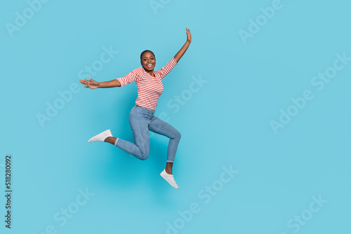 Full body photo of overjoyed cheerful lady jump have fun good mood isolated on blue color background © deagreez