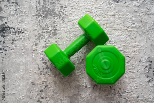 green dumbbells weight on a grey carpet floor background, concept of fitness sport healthy lifestyle 