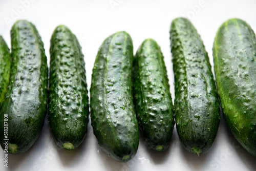 Green juicy cucumbers on a white background.