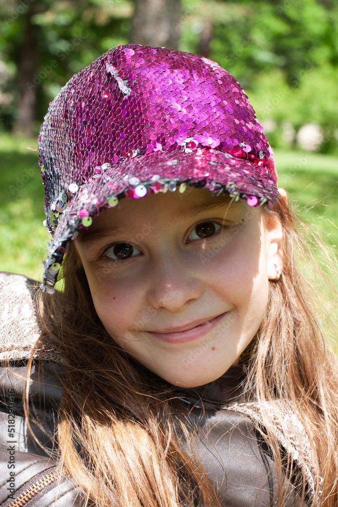 Portrait of caucasian cute girl who smiling and posing with a cap with the sequins while looking at camera Portrait of caucasian cute girl who smiling and posing with a cap with the sequins while looking at camera