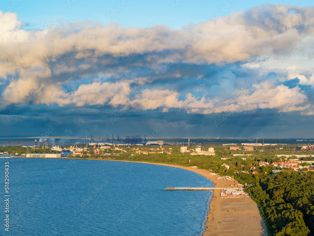 Moody sky over Baltic sea coast towards Gdansk shipyard, aerial landscape at dusk