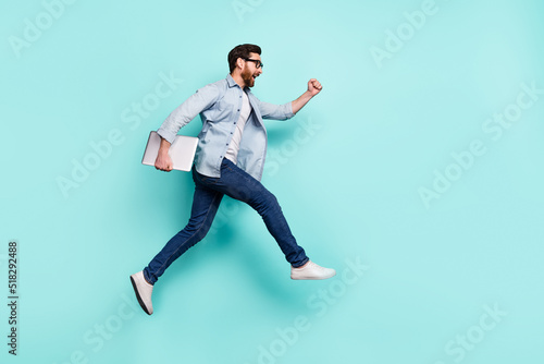 Full size portrait of active energetic person hurry rush fast empty space isolated on turquoise color background © deagreez