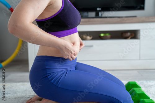 woman in sport outfit with extra weight, kg belly, not perfect body is exercising and loosing weight, concept of sport and fitness and healthy lifestyle