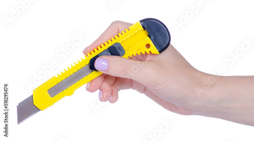 Yellow stationery knife in hand on white background isolation photo