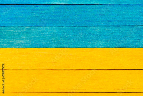 Wooden textured boards in blue and yellow colors . Blue and yellow separated wooden background. 