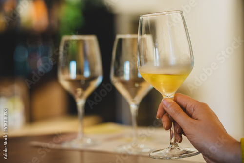 Woman is tasting white wine at a winery.