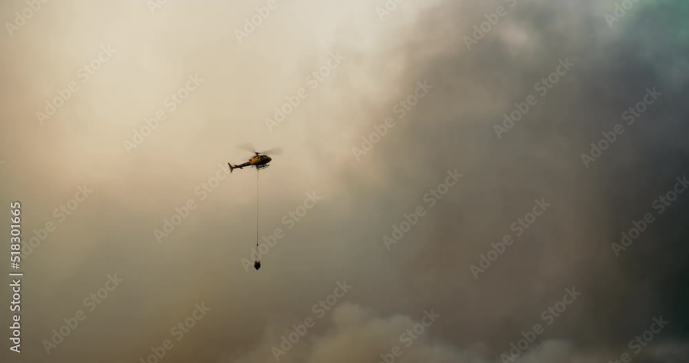 Firefight helicopter on sky and smoke background fly and dropping water to the forest. Breaking news wildfire destroying the natural park and create ecology pollution and catastrophe. Firefight helicopter on sky and smoke background fly and dropping water to the forest. Breaking news wildfire destroying the natural park and create ecology pollution and catastrophe.