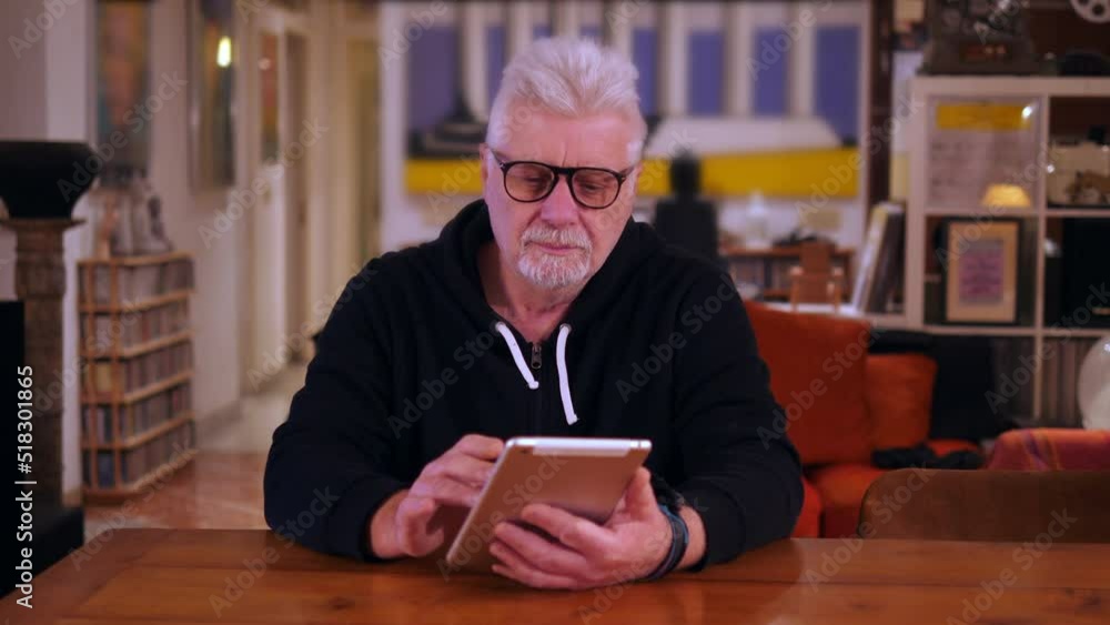 portrait of focused man learns to use ipad by adapting to new technologies portrait of focused man learns to use ipad by adapting to new technologies