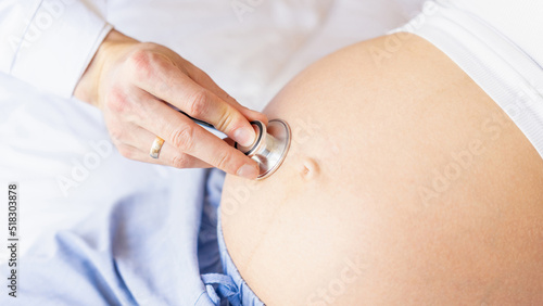 Pregnant woman doctor hospital. Medical clinic for pregnancy consultant. Doctor examining pregnancy woman belly holding stethoscope. Therapy, healthcare, motherhood concept.