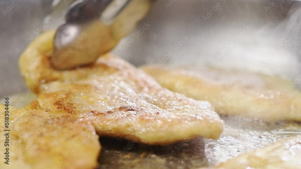 Chef prepares chicken breasts in a frying pan.
Chef prepares chicken breasts in a frying pan.