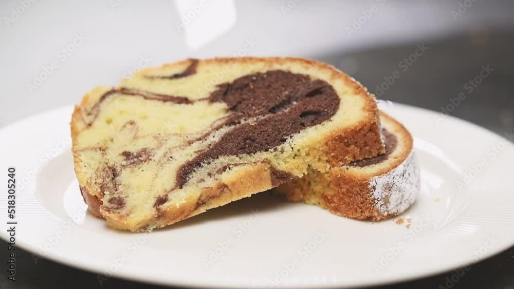 Confectioner serves a piece of marble cake on a plate.
Confectioner serves a piece of marble cake on a plate.