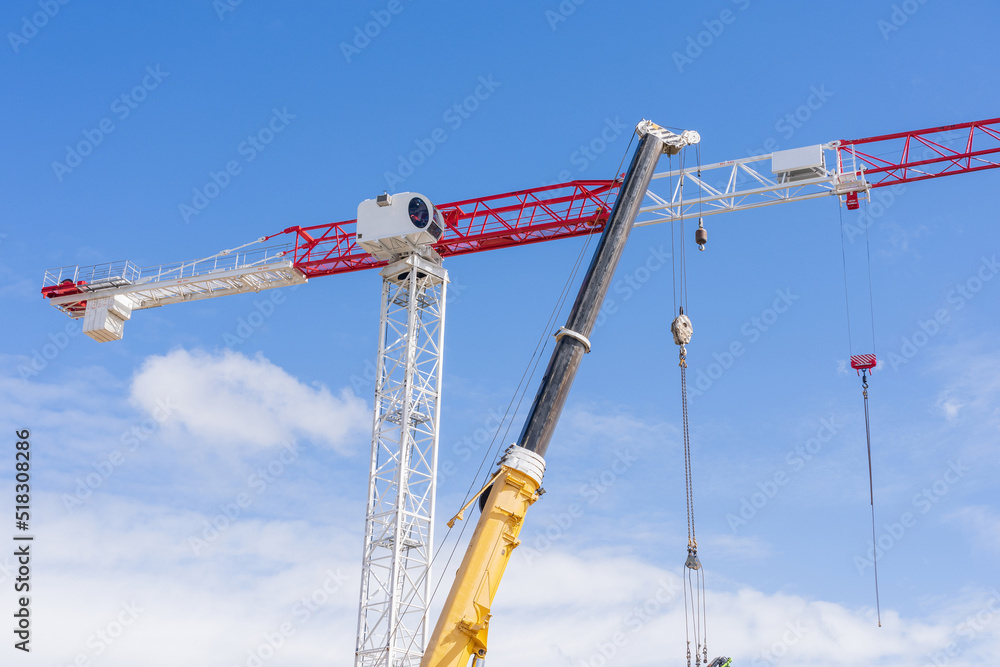 Looking up at tall cranes with chains hanging from them Looking up at tall cranes with chains hanging from them
