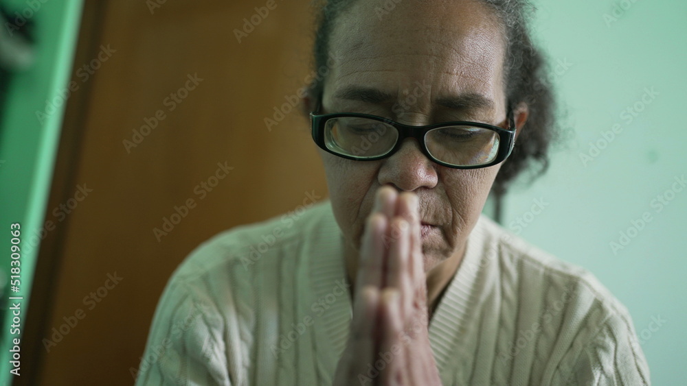 Religious older person praying at home. One hispanic senior woman prays to God Religious older person praying at home. One hispanic senior woman prays to God