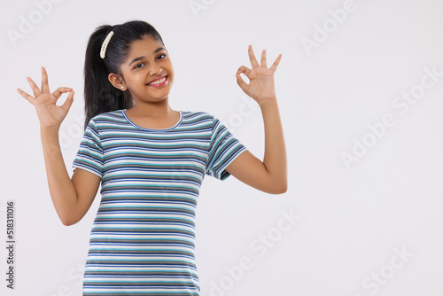 Portrait of a cheerful girl gesturing against white background